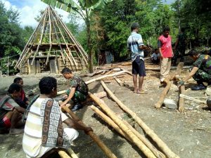 Nampak para personil Pamtas Yonif Raider 321/GT Kostrad sedang bekerja membangun rumah-rumah adat di kawasan NTT Utara.